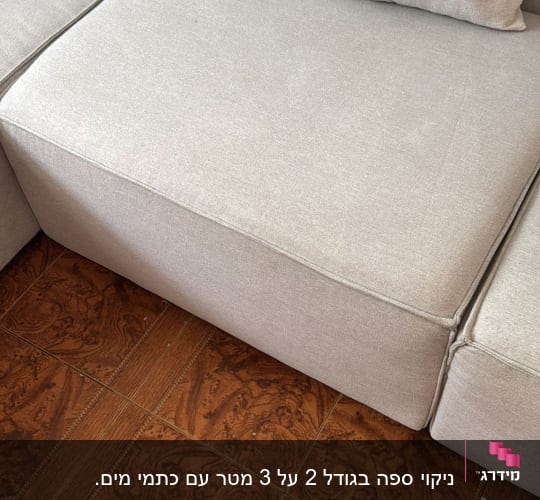 ספה אפורה עם כריות על רצפת עץ